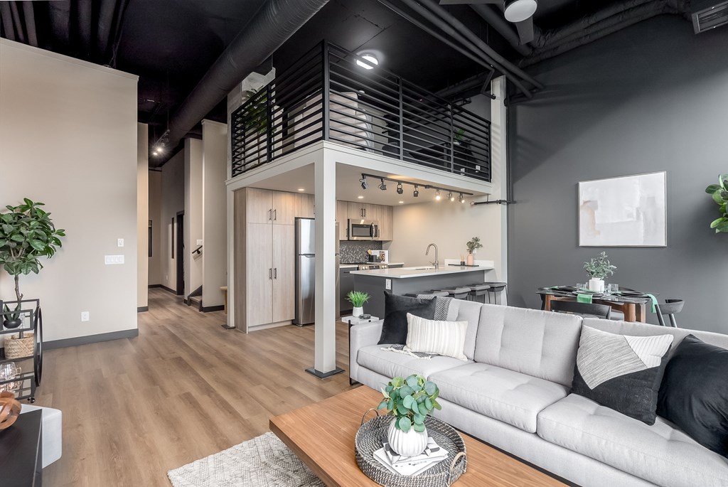 A modern living room with a grey sofa and a wooden coffee table.at Raymond Block, Edmonton, AB
