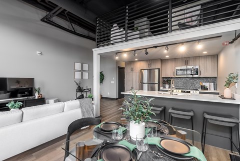 A modern dining area with a table set for a meal.at Raymond Block, Edmonton, T6E 3R7