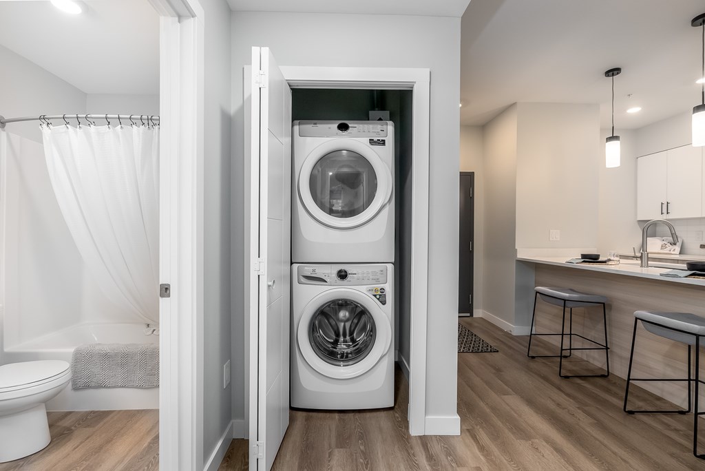 A white washer and dryer are in a small laundry room.