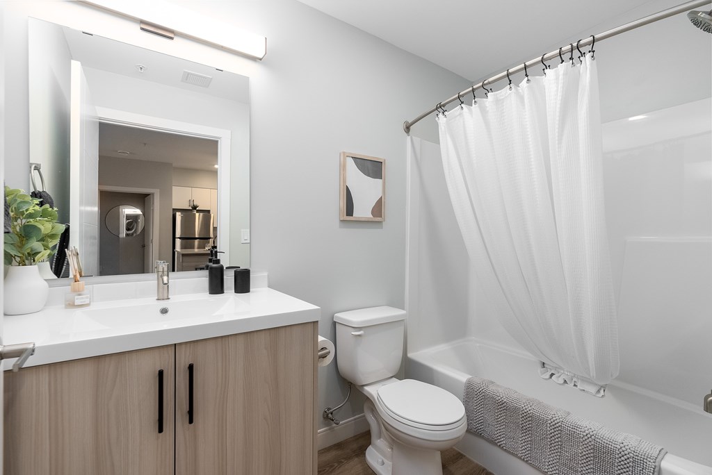 A white bathroom with a toilet, sink, and shower.