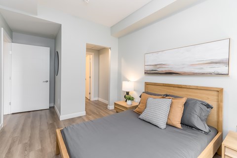 A bedroom with a large bed and a painting on the wall.