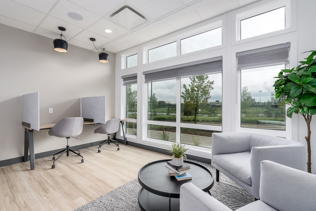 a living room with a large window and a table with chairs