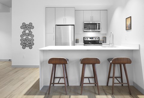a kitchen with three wooden stools in front of a counter top