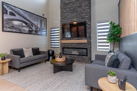 A living room with a grey couch, a coffee table, and a fireplace. at Vibe Apartments at Arbour Lake, Alberta