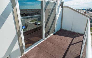 A balcony with a view of the street below.