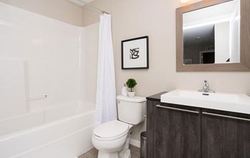 A white toilet sits next to a white sink in a bathroom.