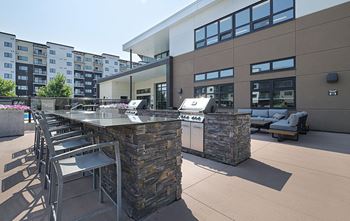 A patio area with a stone barrier and chairs.