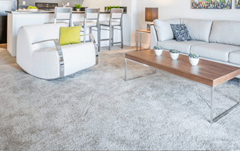 A white chair with a yellow pillow sits in a living room.
