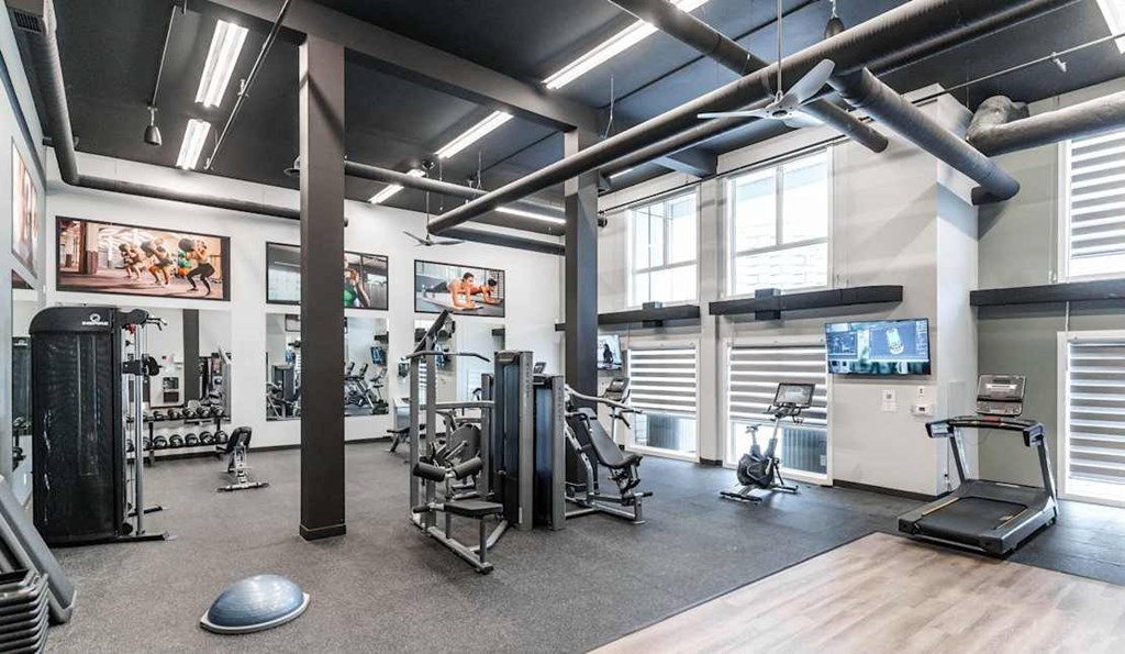 A gym with a variety of equipment including treadmills, weights, and exercise machines.at Skyway Apartments, Calgary Alberta