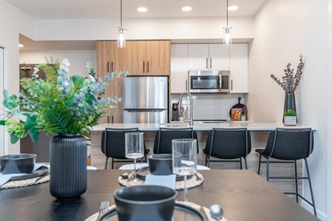 A modern dining room with a table set for six.at Vibe Apartments at Arbour Lake, Calgary, T3G 4J2