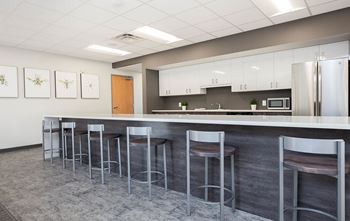 A modern kitchen with a bar area featuring stools.