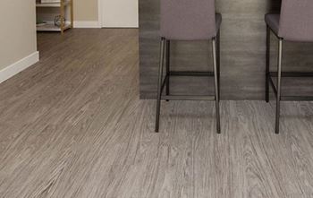 Two chairs are placed in front of a wooden wall.