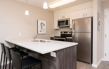 A kitchen with a white countertop and stainless steel appliances.