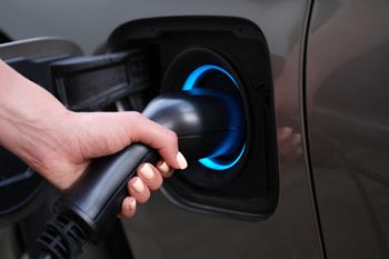 a hand holding a gas pump nozzle at Vibe Apartments at Arbour Lake in Calgary, AB, T3G 4J2