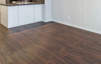 A kitchen with a wooden floor and white cabinets.