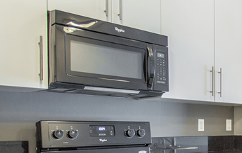 A black microwave oven mounted above a stove.