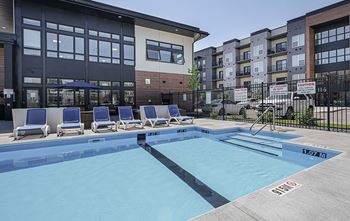 A swimming pool in front of apartment buildings.