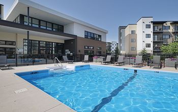 A swimming pool in front of a building with a sign that reads "Park 1.3 M".