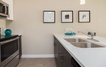 A kitchen with a stove, oven, and sink.