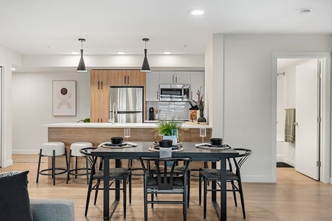 A modern dining room with a table set for four.