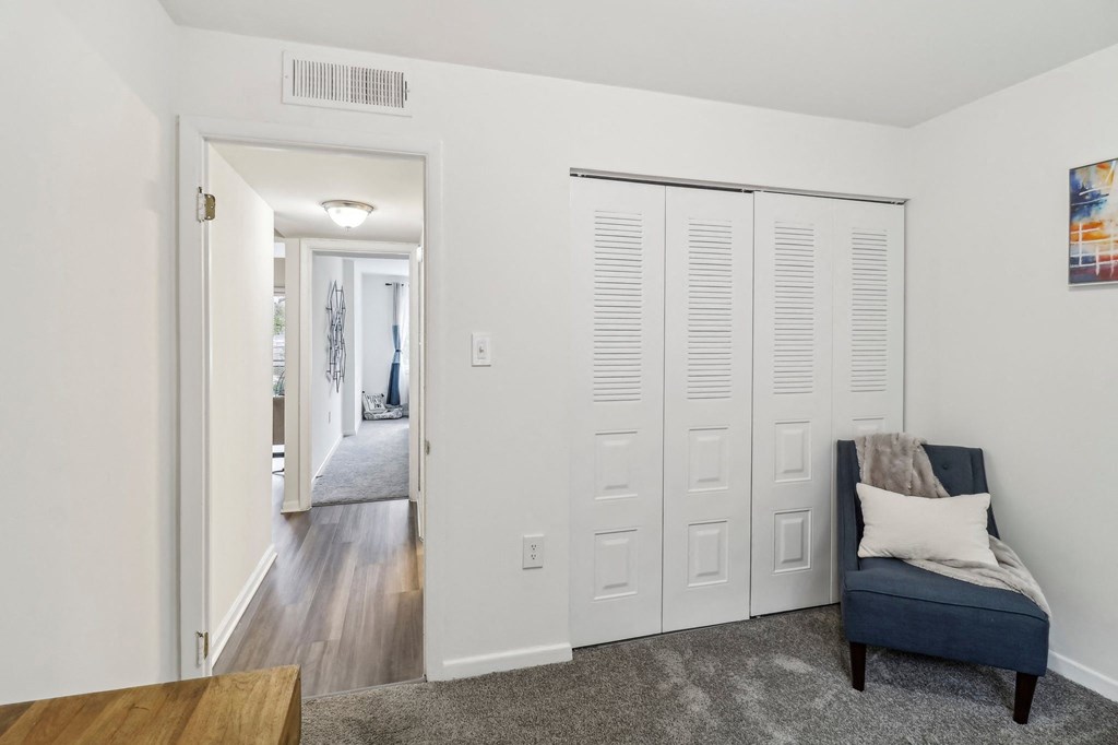 a living room with white doors and a blue chair at Oaks at Oxon Hill, Oxon Hill, Maryland