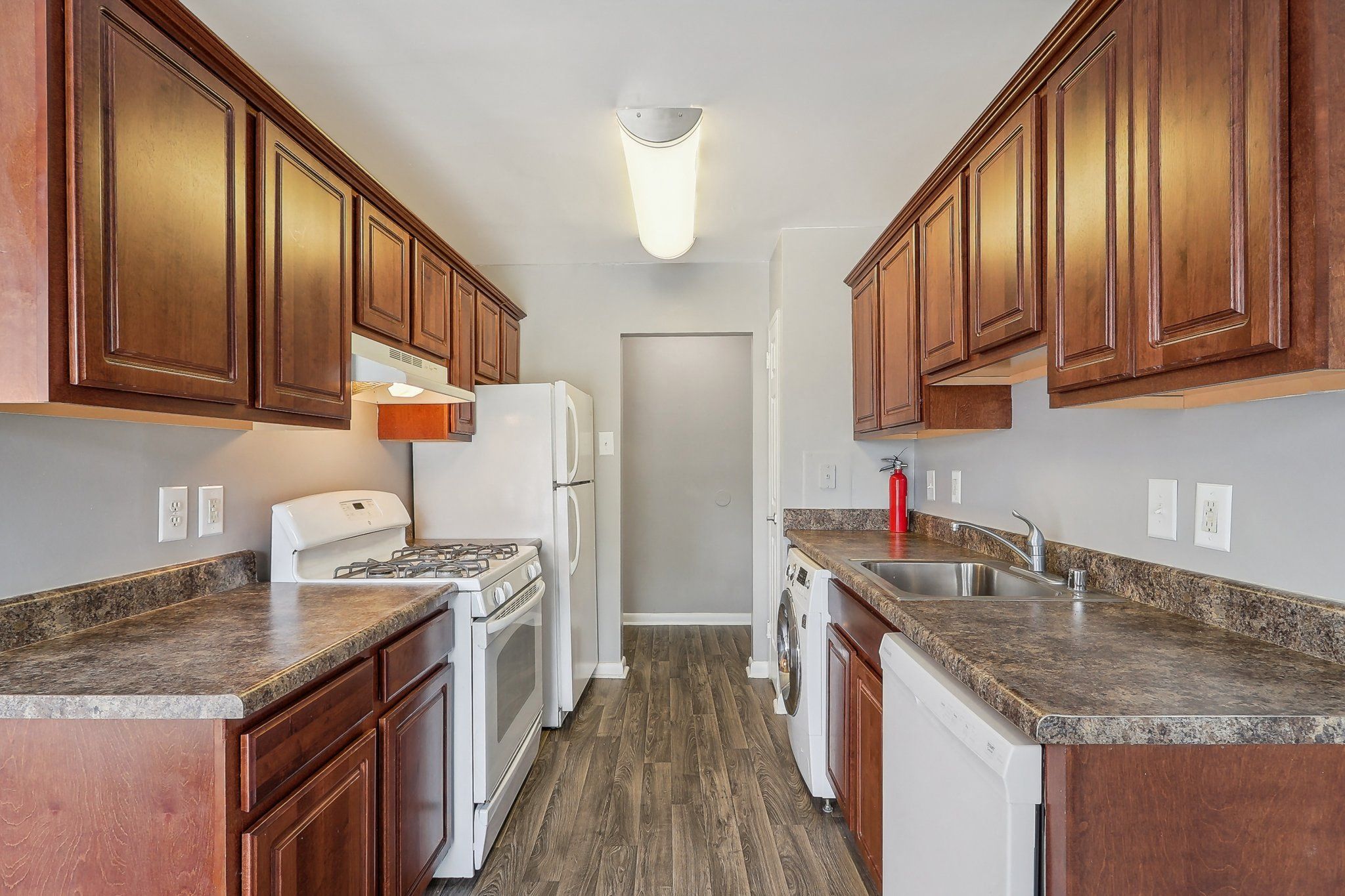 a kitchen with white appliances and wooden cabinets