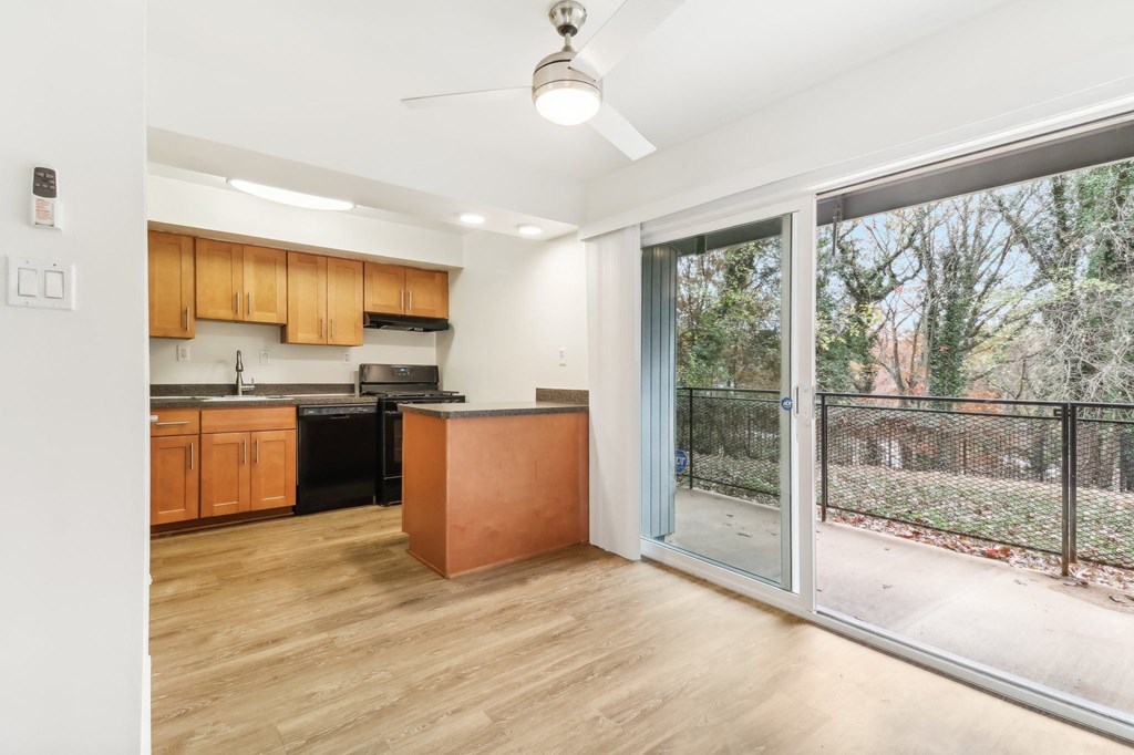 an empty living room with a sliding glass door to a kitchen at Oaks at Oxon Hill, Oxon Hill, Maryland