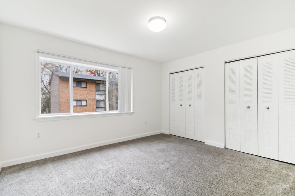 a room with two closets and a window and a carpeted floor at Oaks at Oxon Hill, Oxon Hill, Maryland