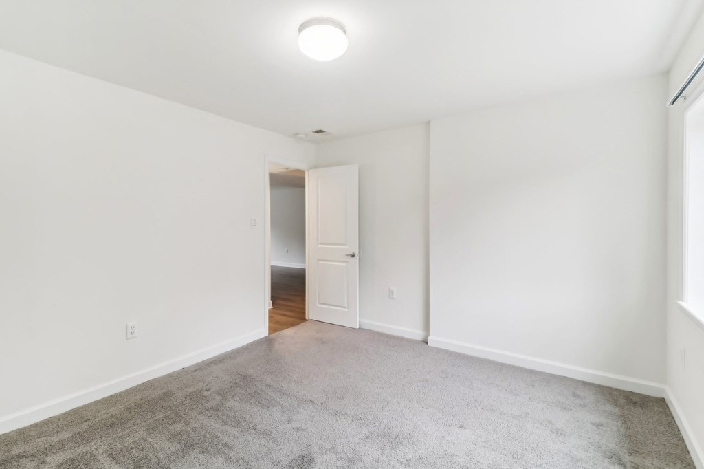 a living room with a carpeted floor and white walls at Oaks at Oxon Hill, Oxon Hill, Maryland