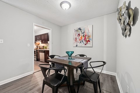 A dining room with a table and chairs.