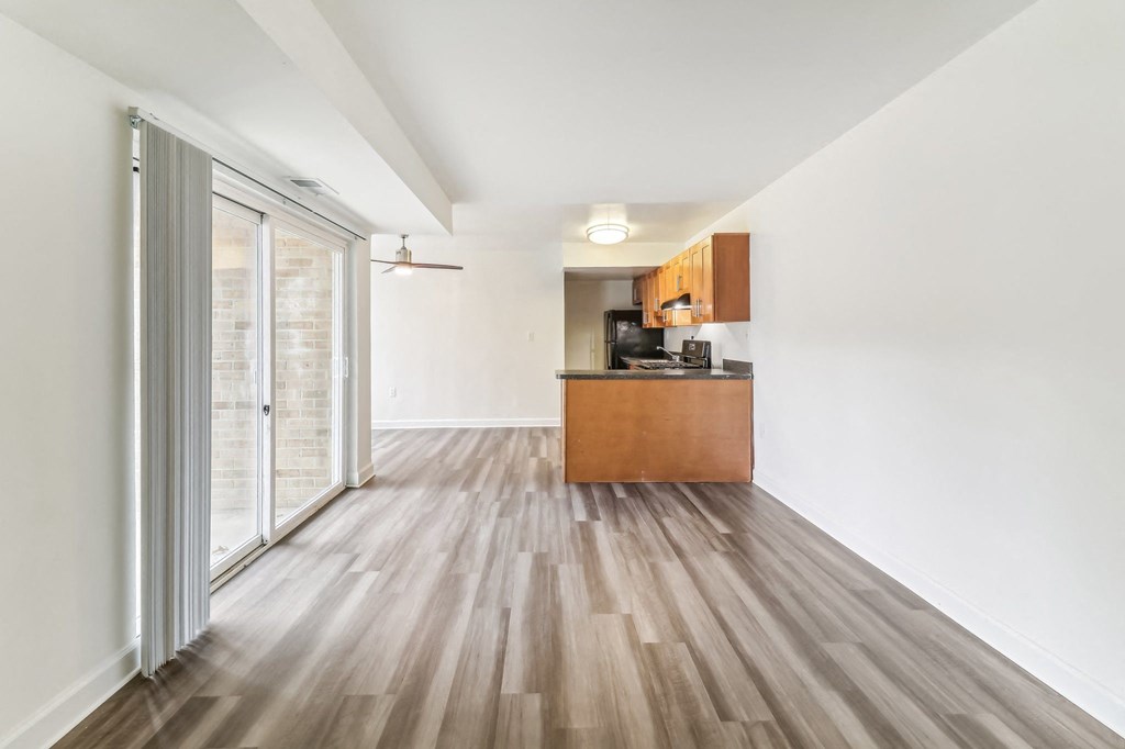 a living room and kitchen with wood floors and a sliding glass door at Oaks at Oxon Hill, Oxon Hill, Maryland