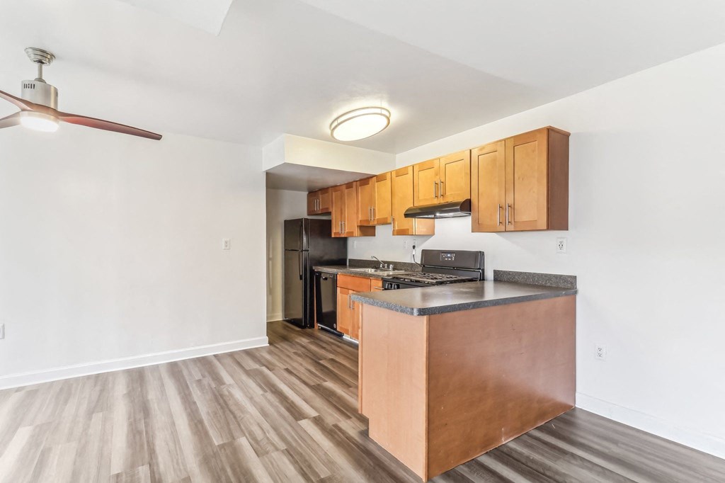 a kitchen with wooden cabinets and a counter top and a stove and refrigerator at Oaks at Oxon Hill, Oxon Hill, Maryland