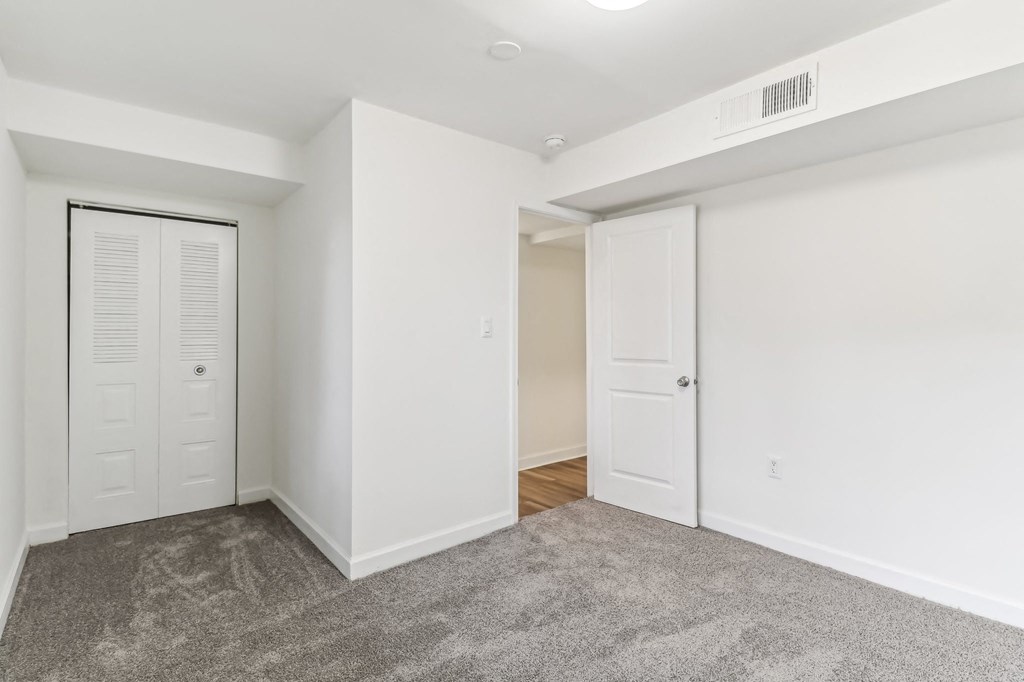 a room with white walls and a carpet and a closet at Oaks at Oxon Hill, Oxon Hill, Maryland