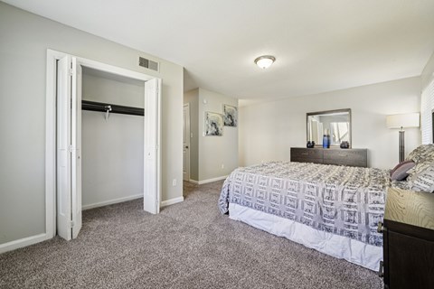 A bedroom with a bed, dresser, and mirror.