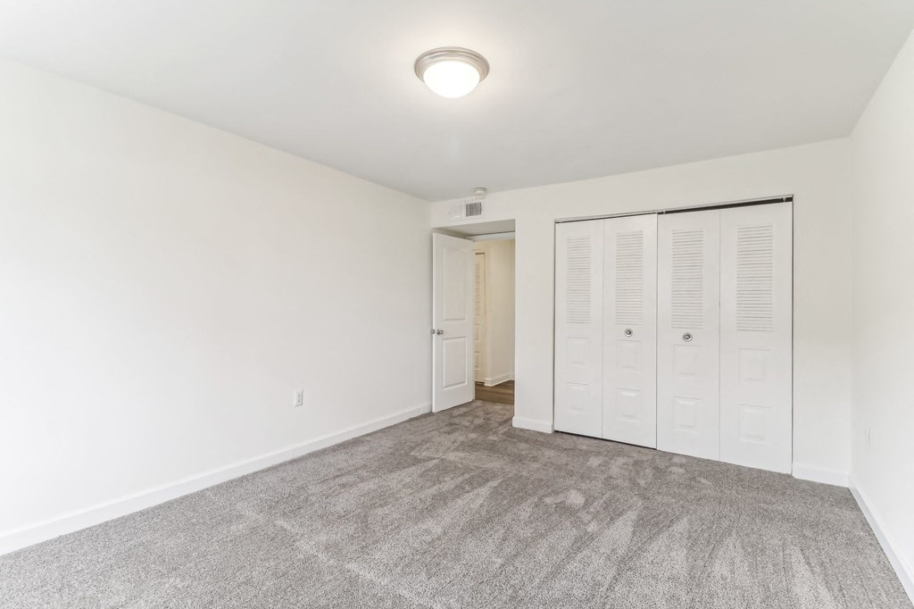 a bedroom with white walls and a door to a closet at Oaks at Oxon Hill, Oxon Hill, Maryland