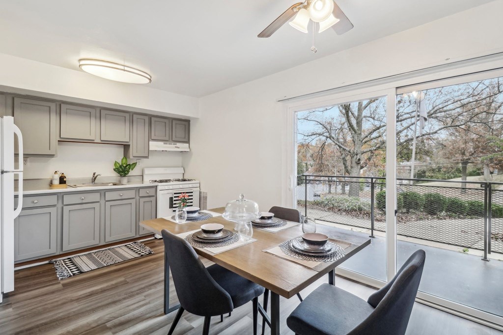 a living room with a large window and a table with chairs at Oaks at Oxon Hill, Oxon Hill, Maryland
