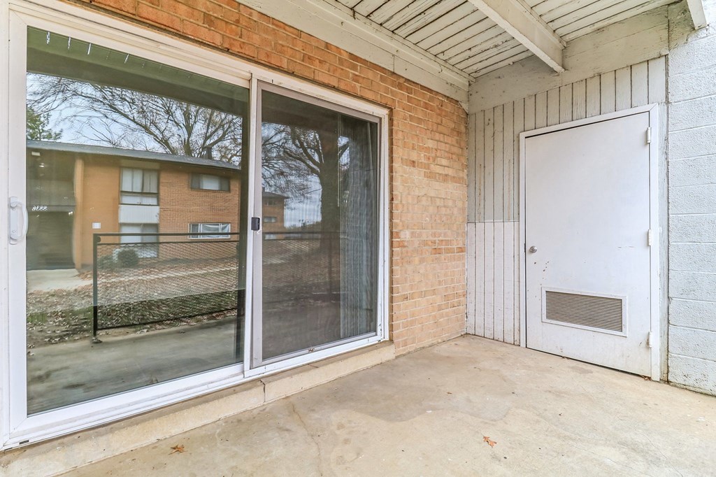 the patio of a building with sliding glass doors and a fence at Oaks at Oxon Hill, Oxon Hill, Maryland