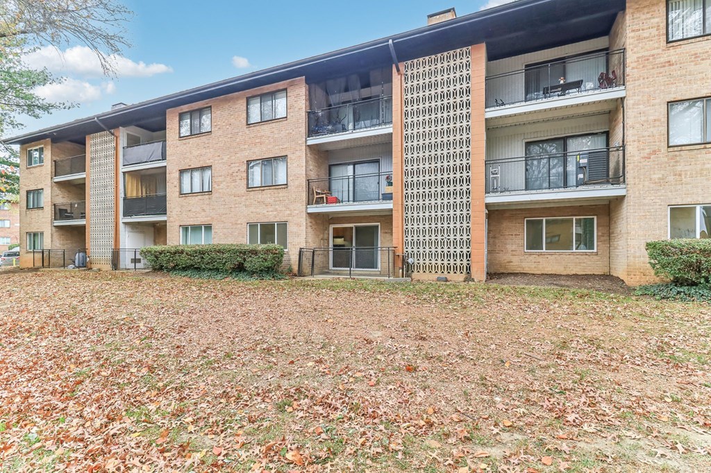 an exterior view of an apartment building with fallen leaves at Oaks at Oxon Hill, Oxon Hill, Maryland