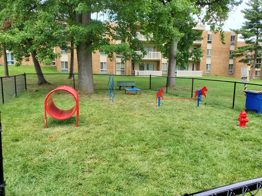 a playground in a park with trees and a fire hydrant at The Glendale Residence, Maryland, 20706