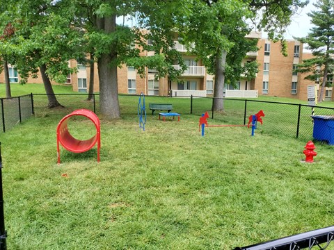a playground in a park with trees and a fire hydrant at The Glendale Residence, Maryland, 20706