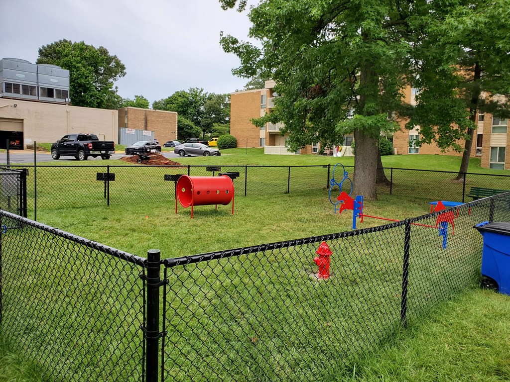 a red fire hydrant in the grass next to a fence at The Glendale Residence, Maryland, 20706