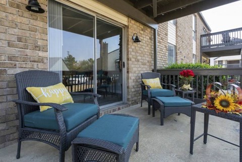 A patio with two chairs and a table with a sunflower on it at The Onyx Hoover Apartments, Alabama