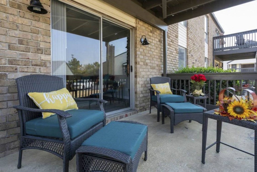 A patio with two chairs and a table with a sunflower on it. A patio with two chairs and a table with a sunflower on it at The Onyx Hoover Apartments, Alabama