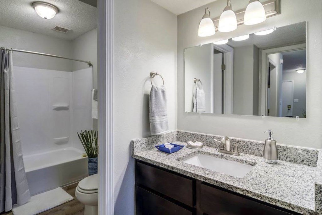 A bathroom with a marble countertop and a large mirror. A bathroom with a marble countertop and a large mirror at The Onyx Hoover Apartments, Hoover, 35216