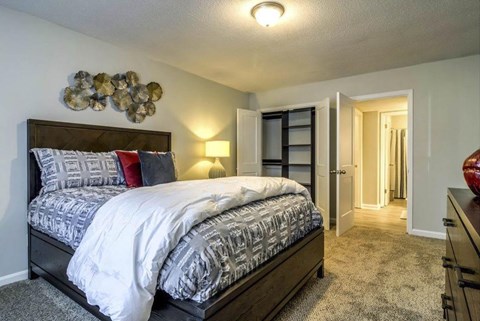 A bedroom with a large bed and a wall decoration at The Onyx Hoover Apartments, Hoover