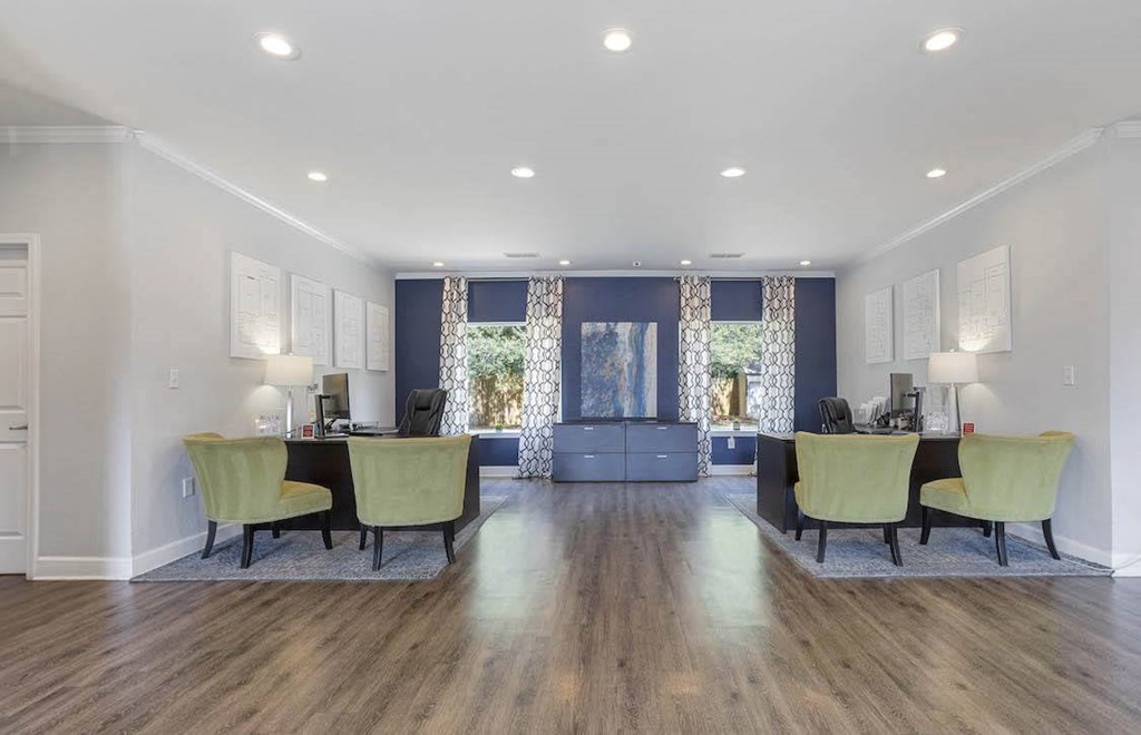 A spacious room with a desk and chairs in the foreground and a couch in the background. A spacious room with a desk and chairs in the foreground and a couch in the background at The Onyx Hoover Apartments, Hoover, Alabama