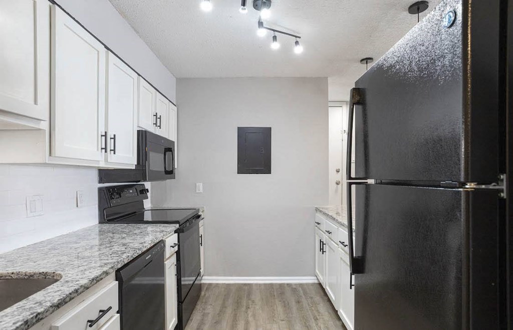 A black refrigerator is on the right side of a kitchen. A black refrigerator is on the right side of a kitchen at The Onyx Hoover Apartments, Hoover, AL