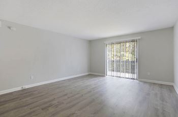 A room with wooden flooring and a window with blinds at The Onyx Hoover Apartments, Alabama