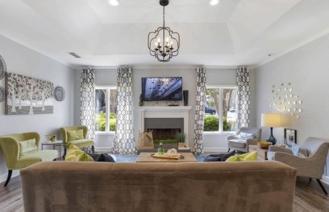 A living room with a brown couch and a chandelier at The Onyx Hoover Apartments, Hoover