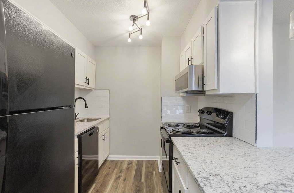 A kitchen with a black refrigerator and white cabinets. A kitchen with a black refrigerator and white cabinets. at The Onyx Hoover Apartments, Hoover, AL, 35216